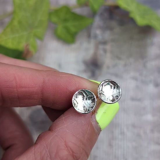 Video of silver honeycomb disc stud earrings held between fingers, showing the honeycomb pattern pressed into the recycled Sterling Silver.