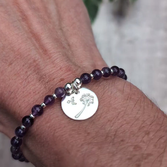 Video of Amethyst and silver dandelion disc bracelet being worn on a wrist, showing the purple amethyst beads and round sterling silver dandelion charm.