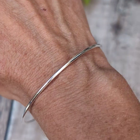 Video of Silver 2mm Smooth Round Bangle handmade from recycled Sterling Silver, shown being worn on the wrist to show the simple smooth design and fit.