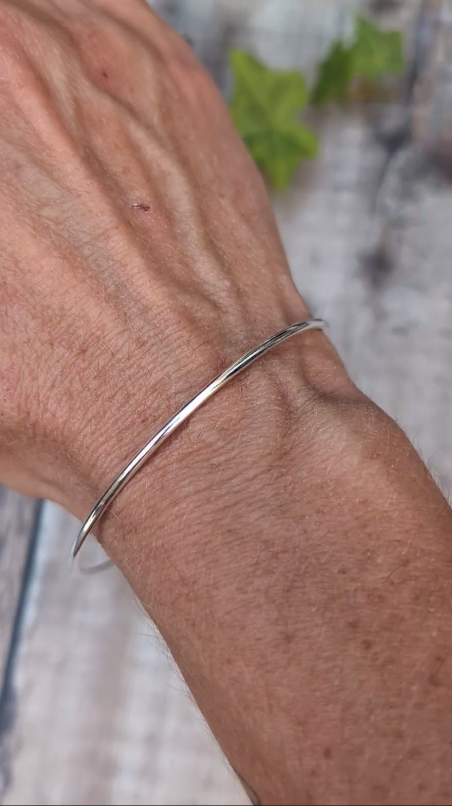 Video of Silver 2mm Smooth Round Bangle handmade from recycled Sterling Silver, shown being worn on the wrist to show the simple smooth design and fit.
