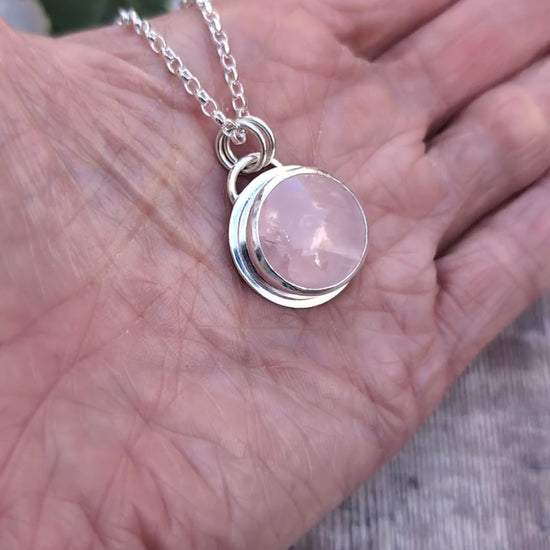 Video of Rose Quartz Statement Gemstone Necklace resting in the palm of a hand, showing the polished recycled sterling silver setting and natural pink Rose Quartz gemstone.