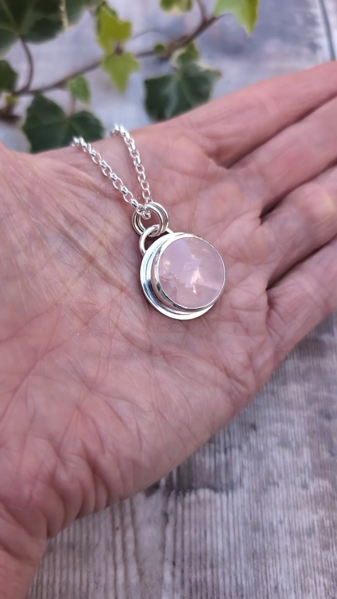 Video of Rose Quartz Statement Gemstone Necklace resting in the palm of a hand, showing the polished recycled sterling silver setting and natural pink Rose Quartz gemstone.