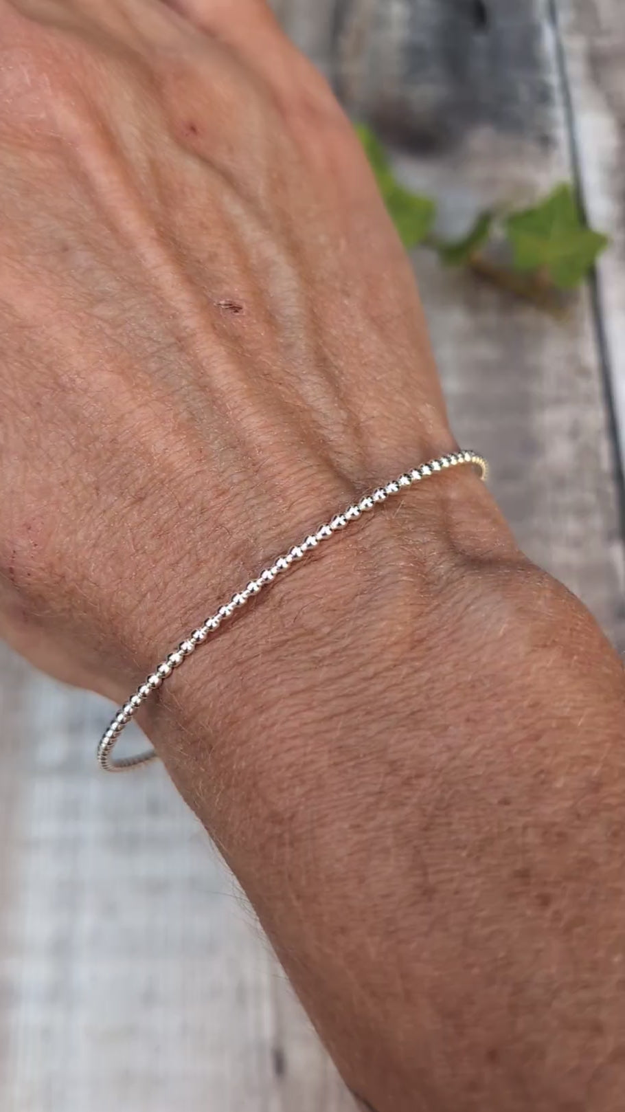 Video of Silver 2mm Beaded Round Bangle worn on the wrist, showing the simple round shape and beaded silver texture.