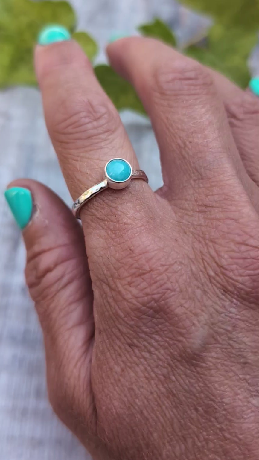 amazonite ring size R being worn on a hand, showing the handmade recycled Sterling Silver band with a round blue green Amazonite gemstone in a simple bezel setting.