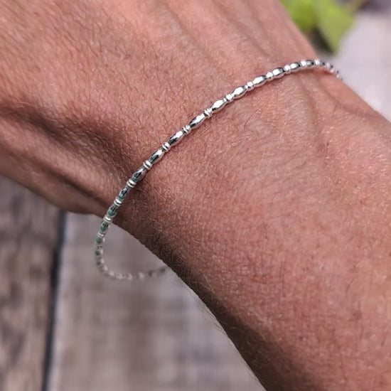 Video of Silver Oval Beaded Wire Round Bangle handmade from recycled Sterling Silver 2mm square wire, worn on the wrist to show the fit and delicate design.