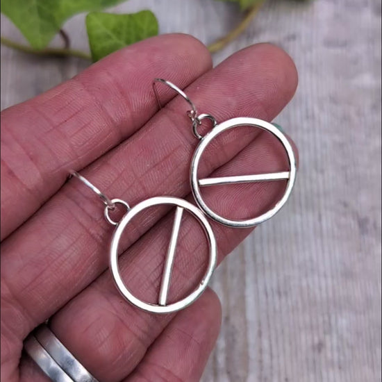 Video of Silver geometric circle earrings handmade from recycled Sterling Silver, shown held in a hand to give an idea of their size.