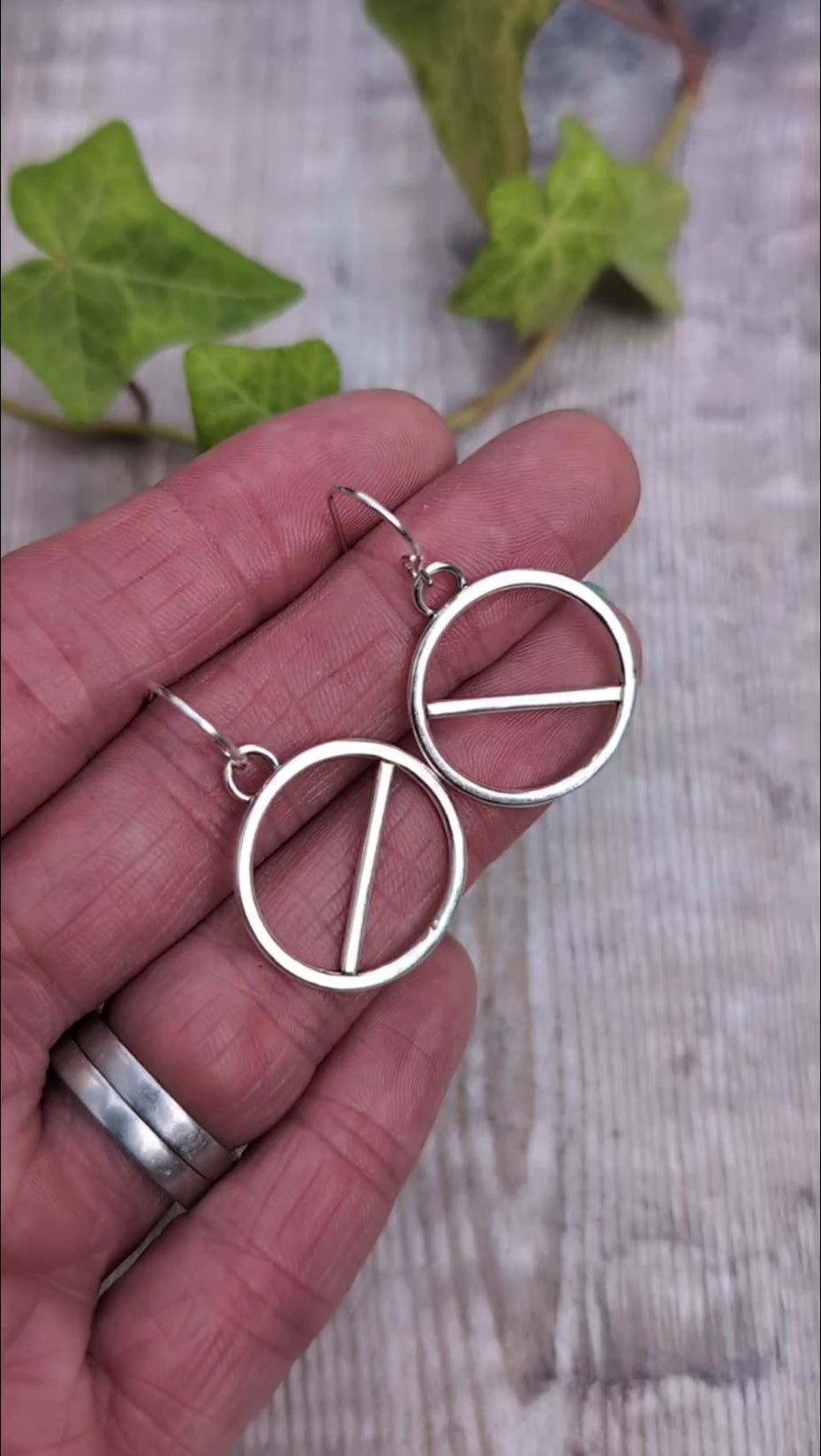 Video of Silver geometric circle earrings handmade from recycled Sterling Silver, shown held in a hand to give an idea of their size.