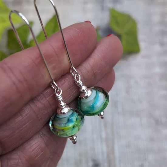 Video of Watercolour Lampwork Glass Long Earrings held in a hand, showing the handmade glass beads and recycled Sterling Silver details.
