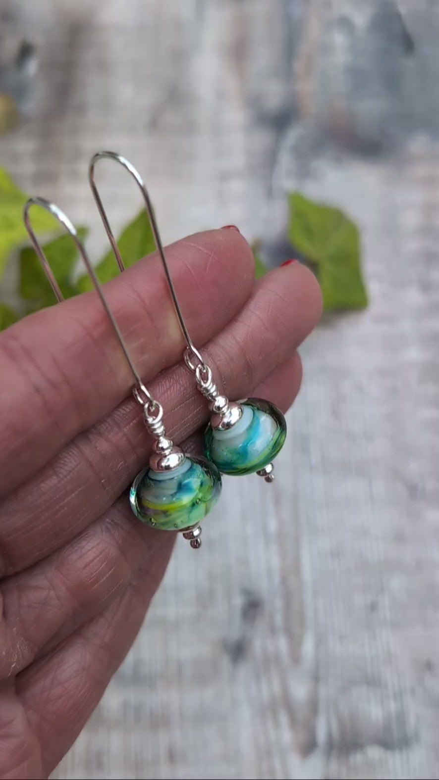 Video of Watercolour Lampwork Glass Long Earrings held in a hand, showing the handmade glass beads and recycled Sterling Silver details.