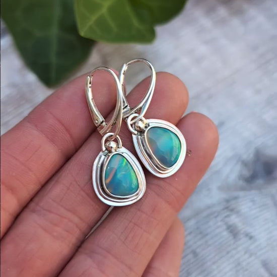 Turquoise Blue Aurora Opal Teardrop Earrings handmade from recycled Sterling Silver, photographed in the hand to show the colourful Aurora Opals and handmade details.