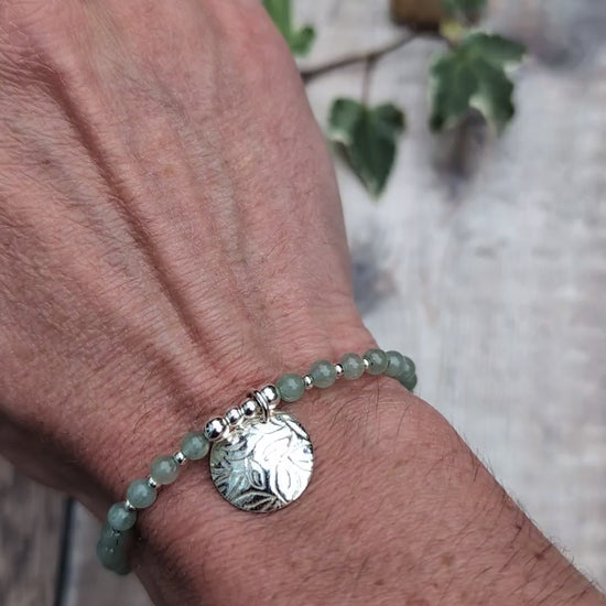 Video of Green aventurine and silver leaf disc bracelet worn on a wrist, showing the textured sterling silver leaf charm and small green aventurine beads separated by silver spacers.