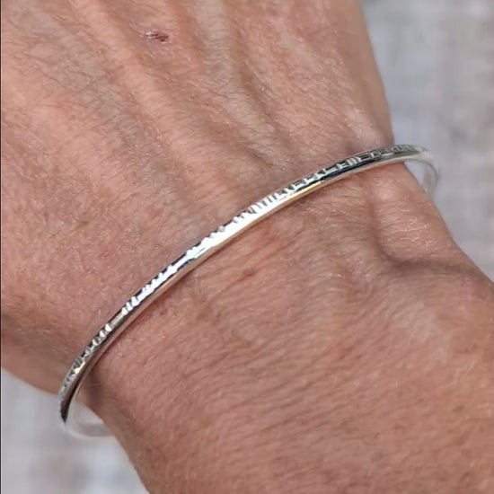 Video of Silver Textured Oval Cuff Bangle worn on the wrist, showing the handmade hammered edge detail and smooth Sterling Silver finish.