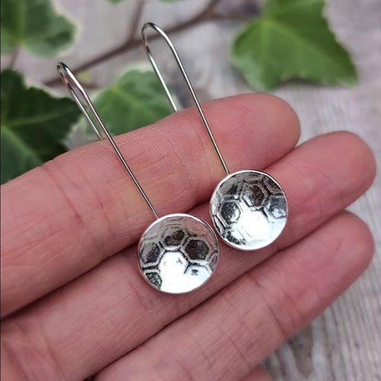 Video of Silver honeycomb long disc earrings handmade from recycled Sterling Silver, held in a hand to show their size and honeycomb texture.