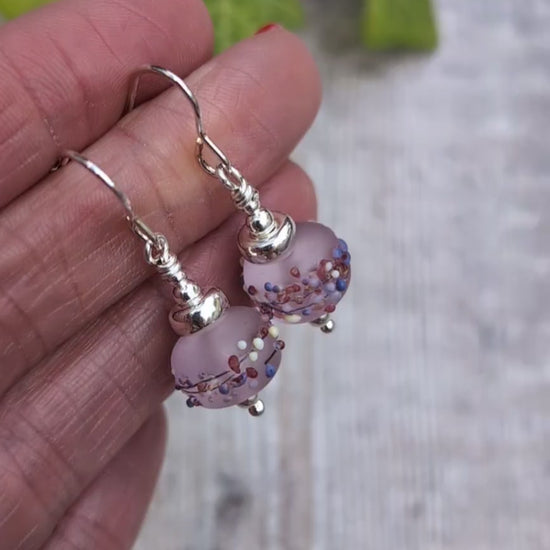 Video of Tropical Pink Lampwork Glass Earrings held in a hand, showing the frosted finish and colourful details on the handmade Lampwork beads.