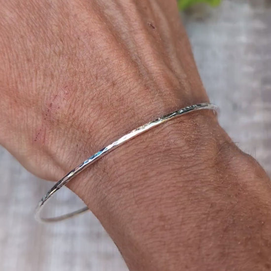 Video of Silver 2mm Hammered Round Bangle worn on the wrist, showing the simple slim design and hand hammered finish.