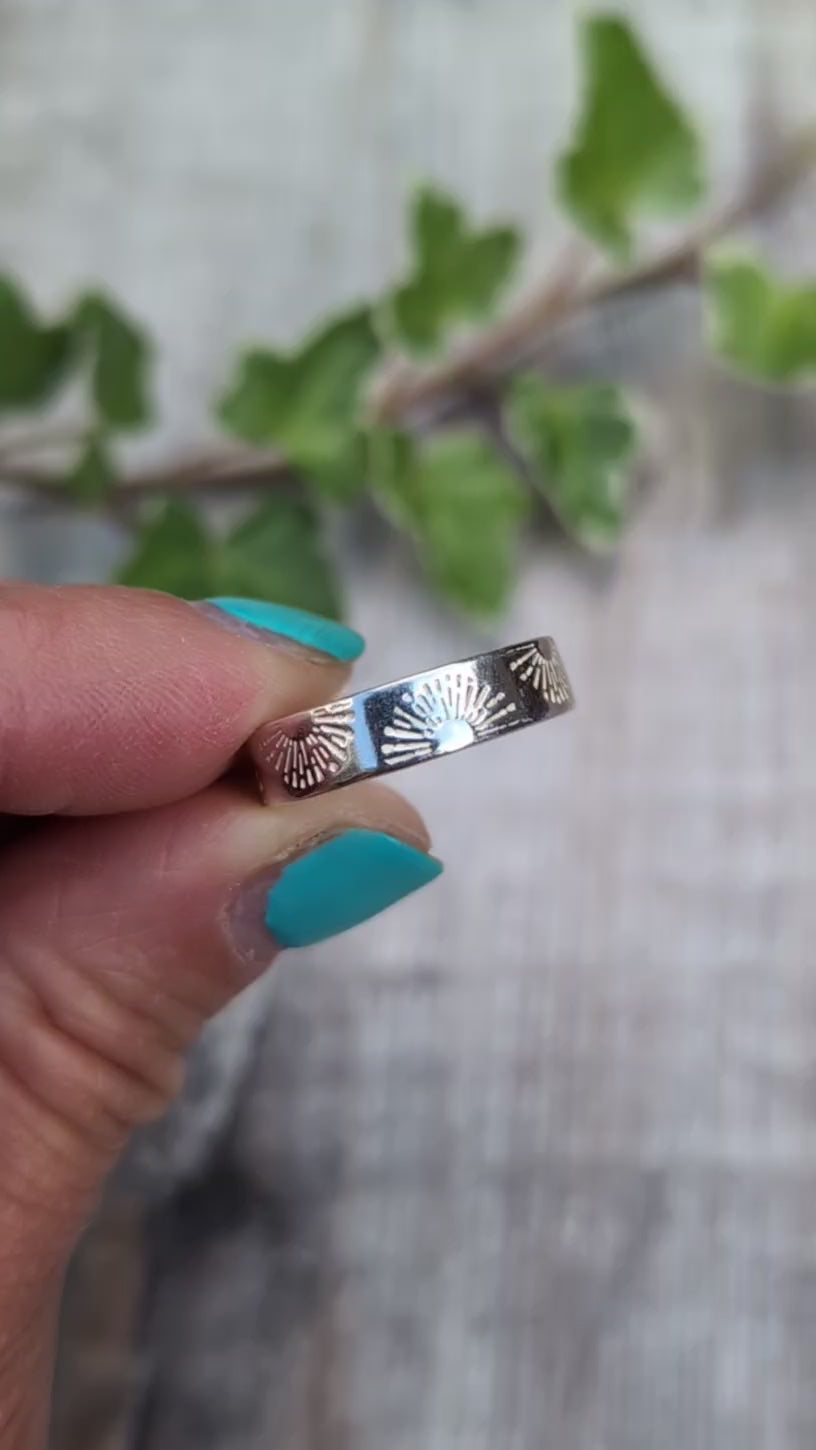 Video of Silver 5mm Sunrise Ring handmade from recycled Sterling Silver with a hand stamped sunrise pattern, shown held between fingers from a different angles. 
