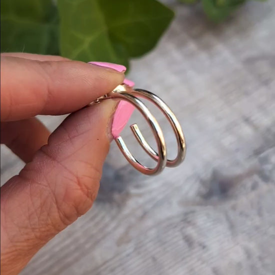 Close up of Silver smooth hoop earrings handmade from recycled Sterling Silver, highlighting the smooth polished finish and post fittings.