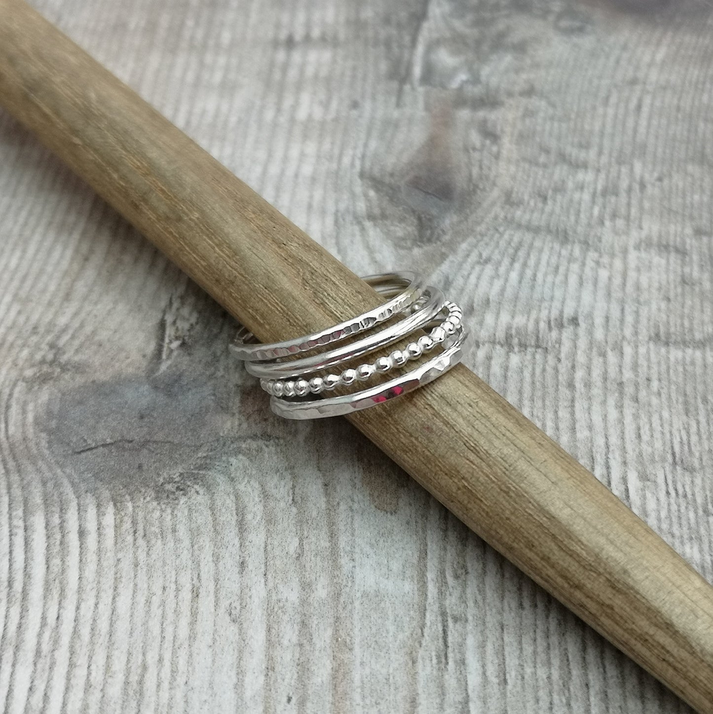 Four separate Sterling Silver rings, one with hammered texture, one beaded texture, one smooth and one lined. For stacking on top of each other, sold separately.